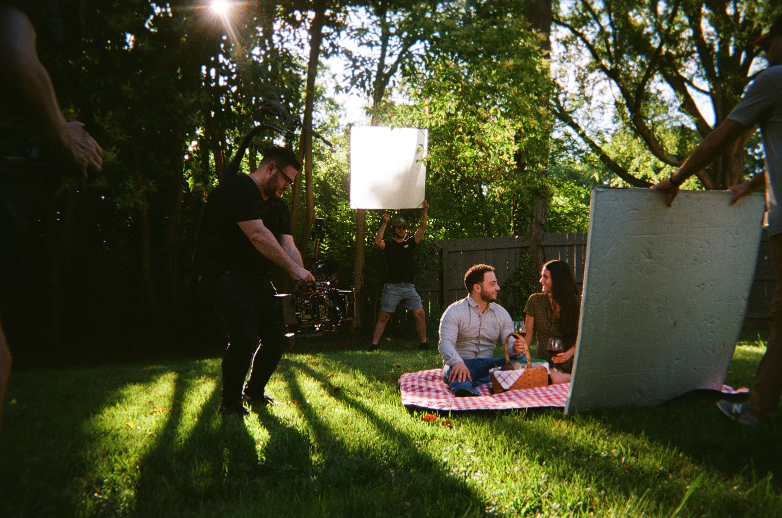 Invest With Roots BTS — backyard picnic scene with crew and bounce boards