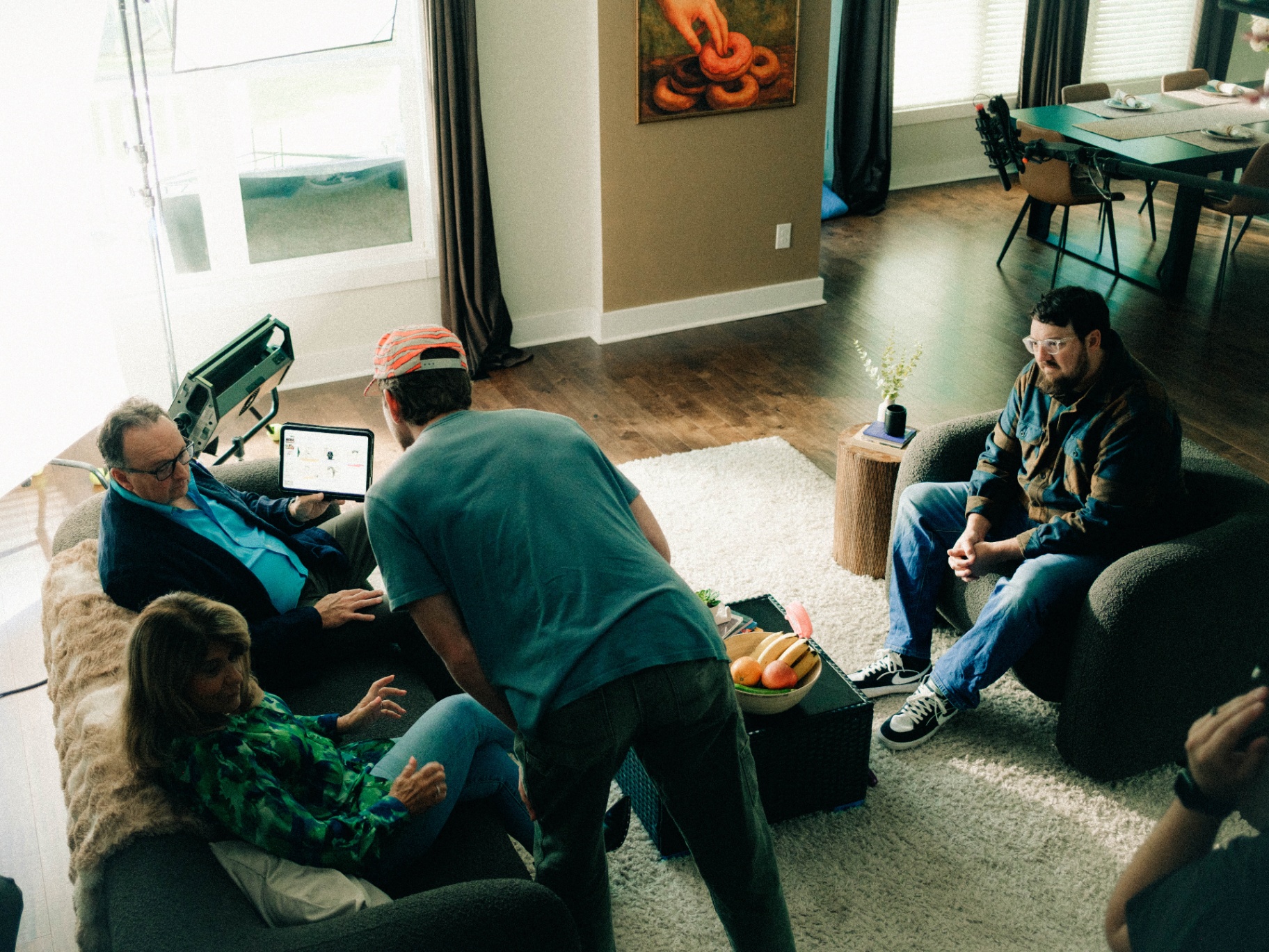 Invest With Roots BTS — director reviewing storyboard with talent on couch